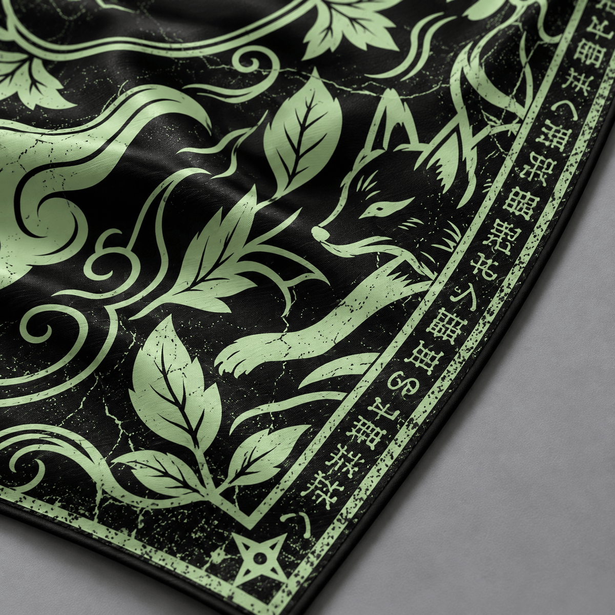 Detalle del zorro, hojas y líneas verdes sobre fondo negro de la bandana KONOHA de seda.